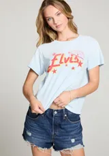 Remera celeste con estampa de la palabra "Elvis" en rojo y amarillo, con estrellas y un diseño de Sun Records.