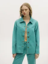 Campera de denim gastado color celeste, con cuello camisero, corte holgado y canesú con costuras delante y atrás.