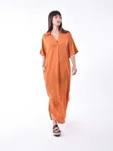 Vestido largo color naranja, de corte amplio, con cuello camisero y mangas cortas.