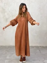 Vestido largo color marrón, de corte suelto, con mangas largas abullonadas y escote en V.
