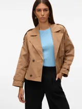 Trench corto color beige con cierre cruzado y bolsillos frontales.