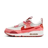 Zapatillas Nike Air Max 90 Futura de mujer, color blanco, rosa y rojo. Confeccionadas con materiales textiles y detalles de gamuza. Presentan la clásica cámara de aire visible en la entresuela y suela de goma con diseño waffle.