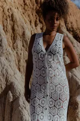 Chaleco largo calado color blanco, tejido al crochet, sin mangas y con caída fluida.