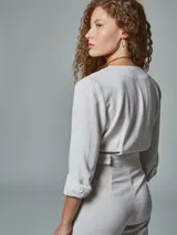 Mono largo color crudo, de lino, con cuello tipo blazer, mangas 3/4 con puños arremangados, cinturón con hebilla forrada y pantalón de corte recto.