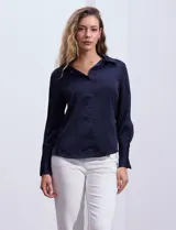Camisa blanca de satén, marca Tahari. Cuello con solapa y escote en V. Abertura central con botones. Manga larga con puño y botón.