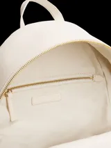 Mochila color crema de poliuretano con cierre de cremallera, asa superior, correas ajustables con inscripción de la marca y bolsillo exterior con cremallera.