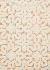 Vestido corto color crema con encaje floral, cuello redondo y sin mangas.