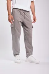 Pantalón deportivo tipo jogger color gris con bolsillos cargo laterales y tobillos ajustados.