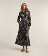 Vestido largo tipo chemise confeccionado en viscolino con estampado floral. Tiene cuello de camisa, mangas largas, abotonadura frontal y lazo en la cintura.