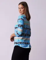 Remera de algodón estampada con rayas horizontales en tonos beige, blanco y negro. Tiene mangas 3/4 y escote a la base.