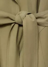 Abrigo largo color beige con cuello de solapa, trabillas en los hombros y cinturón tipo batín.