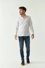 Camisa de hombre a rayas verticales celestes y blancas, corte slim fit, manga larga, logo bordado en el pecho y cartera con botones.