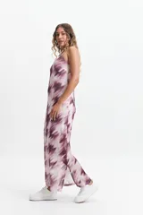 Vestido largo con estampado difuminado en tonos borgoña y blanco, breteles finos regulables y espalda con tiras entrecruzadas. Tiene escote en “V” y tajos laterales.