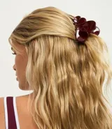 Hebilla para el pelo tipo garra con diseño de doble corazón en color bordó, fabricada en plástico resistente.