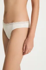 Colaless de tiro bajo color nude, confeccionado en poliamida y elastano, con borde superior decorado con puntilla de encaje.