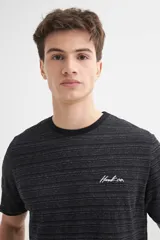 Remera de manga corta color crudo con textura de rayas horizontales y bordado en el pecho.