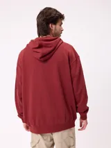 Canguro negro con capucha y cordones ajustables, bolsillo canguro frontal y logo de Rusty estampado en el pecho.