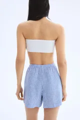 Short de lino celeste con rayas verticales blancas, cintura elastizada con cordón ajustable y corte holgado.