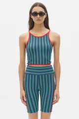 Top deportivo corto negro con cuello halter y tirantes finos en color crema.