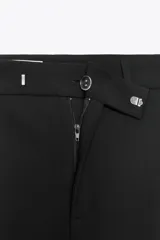 Pantalón negro de vestir, de tiro alto y pierna recta.