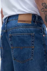 Pantalón de jean azul de corte recto, holgado en la cadera y levemente ajustado en las piernas, con tiro medio.