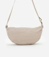 Bolso bandolera mediano color beige con textura drapeada y correa ajustable.