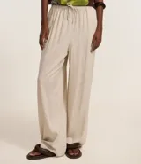 Pantalón femenino de corte fluido, color beige claro, con cintura elástica ajustable mediante un lazo.