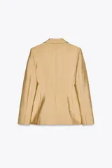 Blazer amplio color dorado confeccionado en hilatura con viscosa. Cuello solapa de muescas y manga larga. Bolsillos con solapa en delantero y de vivo en pecho. Forro interior. Cierre frontal con botones.