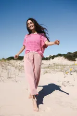 Pantalón de algodón color rosa claro con textura arrugada y cintura elastizada con cordón.