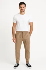 Pantalón babucha color beige con cintura elástica ajustable con cordón, bolsillos laterales y corte holgado.