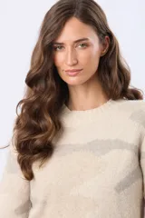 Buzo tejido de punto color beige con estampado de rayas horizontales en tonos grises, cuello redondo y manga larga.