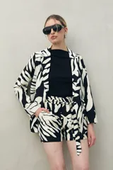 Short de tiro alto con estampado abstracto en blanco y negro, cintura elastizada y lazo para ajustar.