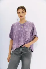 Remera lila con estampado de cachemir, de mangas cortas y cuello redondo. Tiene calce amplio y corte cruzado al frente.