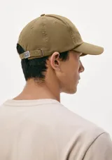 Gorro de gabardina color marrón, con visera curva y correa ajustable en la parte trasera.