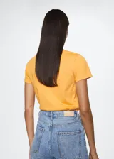 Camiseta de algodón color naranja con logo Mango estampado en el pecho. Diseño recto, cuello redondo y manga corta.