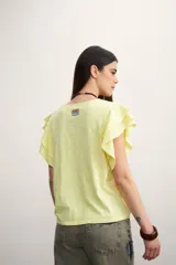 Remera color amarillo pastel con cuello redondo y mangas cortas con volados.