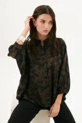 Camisa marrón chocolate con estampado abstracto, cuello mao, mangas 3/4 con puños y cierre frontal con botones.