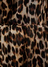 Vestido corto marrón con estampado animal print, cuello redondo con volantes y lazo, manga larga con puños elásticos y falda con volantes.