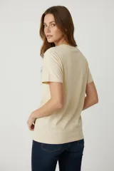 Remera blanca de algodón con estampado de plato con sardinas y texto en color lila.