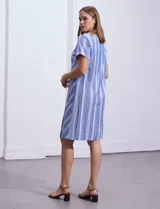 Vestido azul con estampado de líneas diagonales, escote en V y mangas cortas.