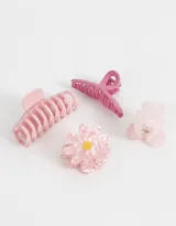 Set de cuatro broches para el pelo de diferentes tamaños y formas en tonos rosados. Incluye un broche tipo pinza, un broche con forma de moño, un broche con forma de flor y un broche pequeño tipo pinza.