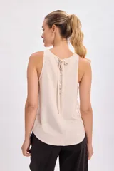Top sin mangas color beige, confeccionado en lino con corte relajado.