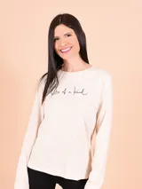 Remera beige de manga larga con la frase "One of a kind" estampada en el frente.