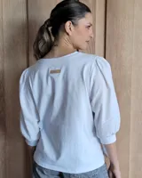 Blusa blanca de mangas 3/4 abullonadas con escote en V.