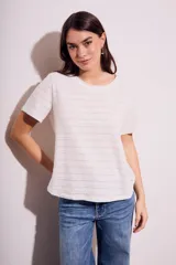 Remera blanca de algodón texturizado con cuello redondo y mangas cortas.