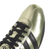 Zapatillas Adidas Tokyo color dorado con detalles en negro, incluyendo las tres tiras laterales y la suela.