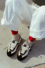 Zapatillas urbanas de cuero color beige con puntera y cordones marrones. Presentan un panel de animal print en el talón y suela de goma color caramelo.