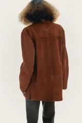 Blazer de cuero color marrón, con cuello solapa de muescas y manga larga. Tiene bolsillos con solapa en delantero, forro interior y cierre frontal con botones.