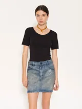 Minifalda de denim con lavado irregular, localizados y desgastes estratégicos. Su superficie presenta un coating especial que genera un acabado simil cuero.