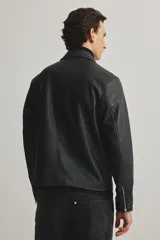 Campera negra de efecto cuero con cuello camisero, cierre frontal y bolsillos laterales con cierre. Presenta un corte estándar y forro interior.